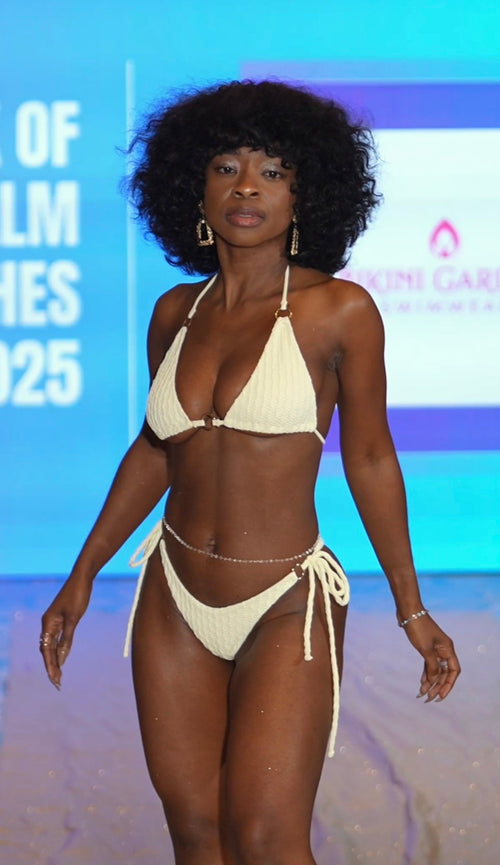 Woman in a beige bikini standing on a runway with a blurred background