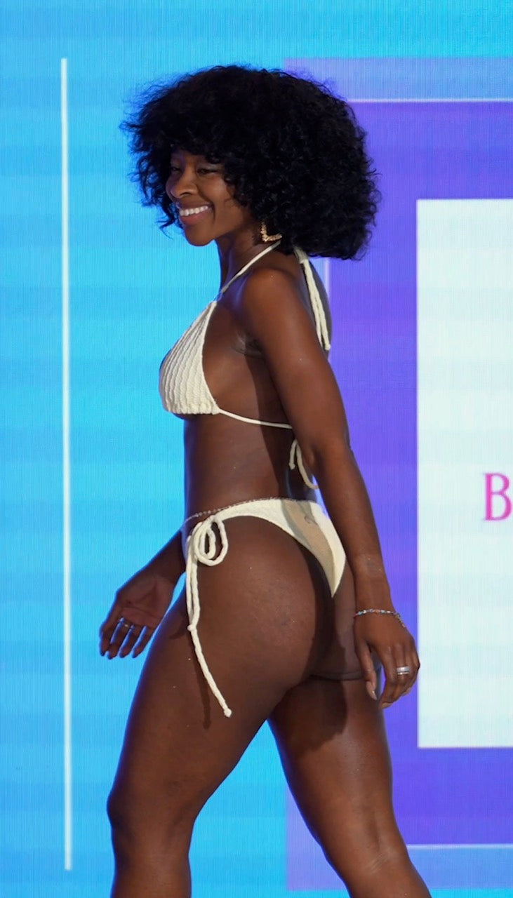 Woman wearing a beige bikini against a blue and purple background